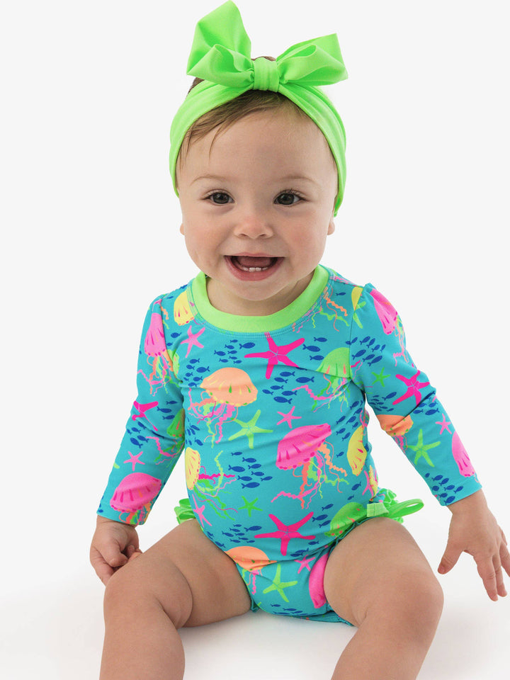 RuffleButts + RuggedButtsLong Sleeve One Piece Rash Guard Swimsuit - Neon Jelly Time